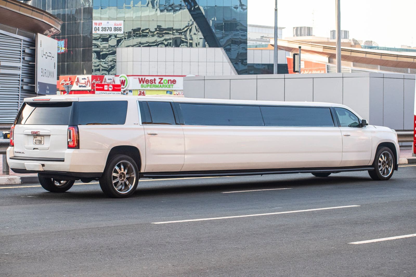 White stretch SUV limousine parked at the curb for a prom pickup